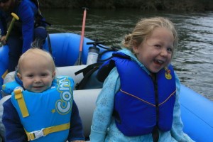 Two children smiling in a boat.